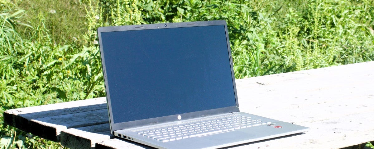 A notebook computer on a picnic table in a local park.