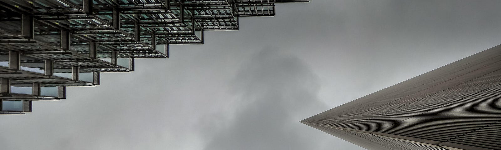 A photo looking up at a gray sky framed by three skyscrapers