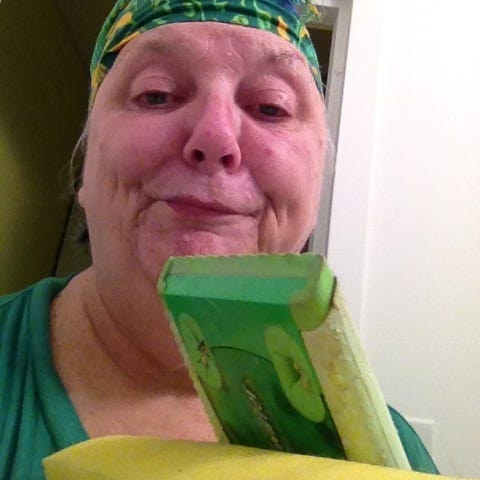 Selfie of woman with Swiffer floor duster and mop