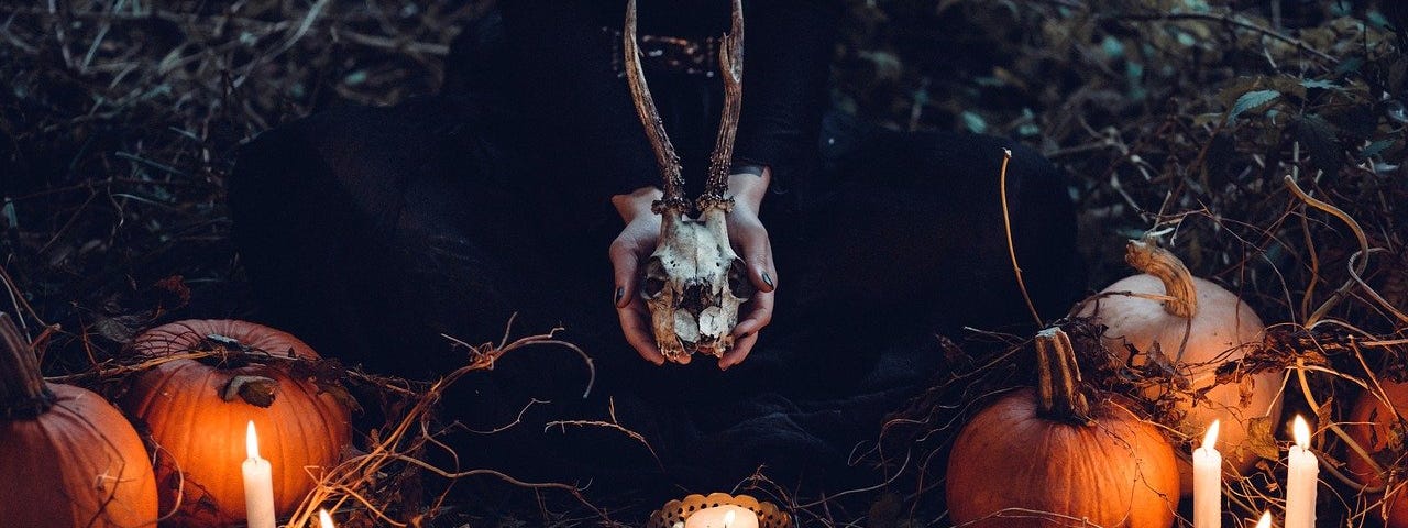 Candles, pumpkins, horned skull.