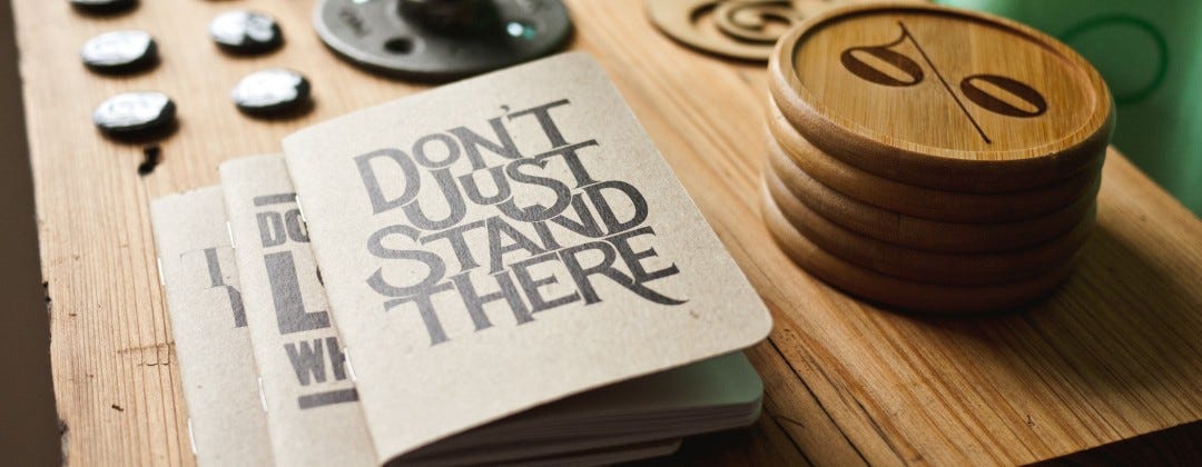 A pamphlet entitled “Don’t Just Stand There” sits on a wooden desk