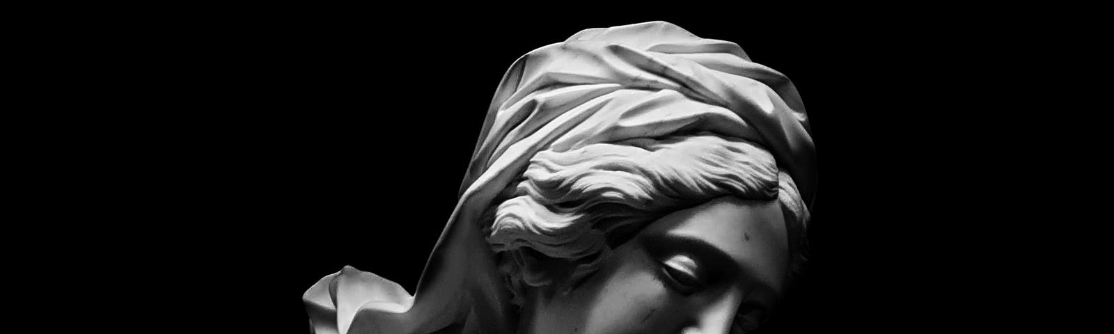 Grayscale photo of an ancient Roman marble sculpture called ‘Maria Annunciata’ by Domenico Guidi