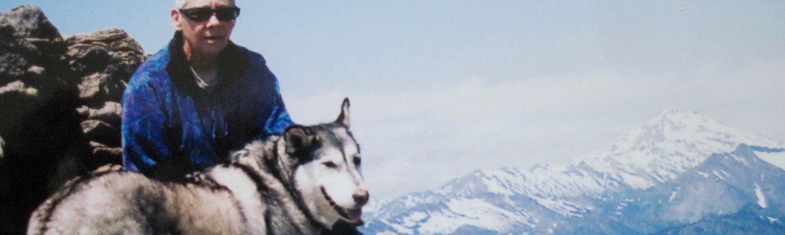 Photo of author on summit of Cascade peak with her husky.