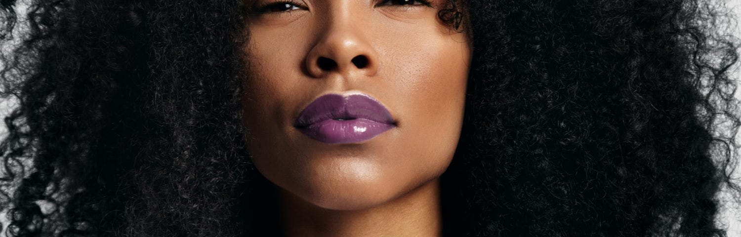 Balck woman with trendy violet glossy lips.