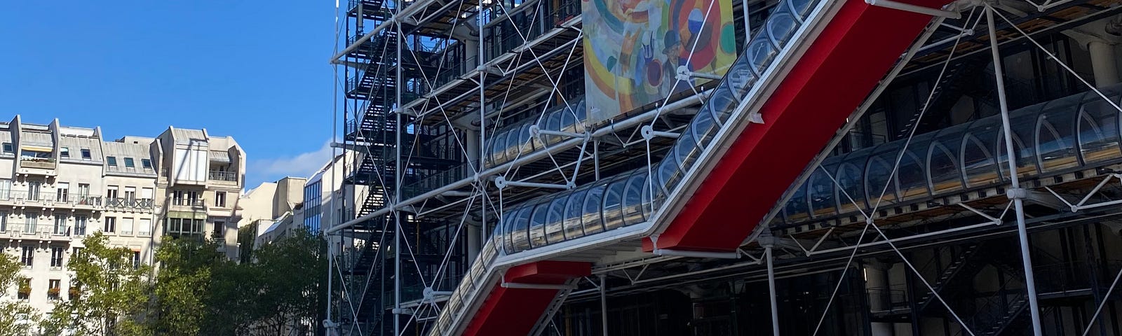 Photography that represent the center Geogres Pompidou, in 19 Rue Beaubourg, 75004 Paris. We can see the outstanding architecture of the 10 levels and 7,500 m2 building. There is a very strong presence of four strong colors — blue, red, yellow and green — that enliven its facades and dress its structure, according to a “code” defined by the architects.