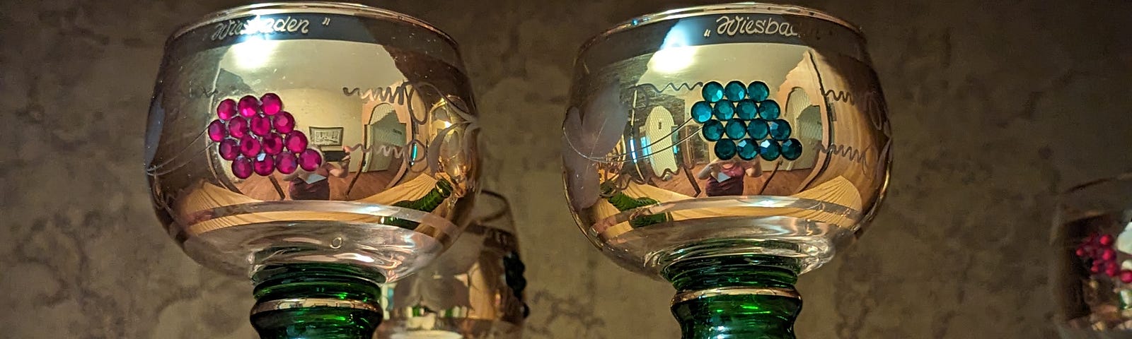 This shows two wine goblets that are gold and green.