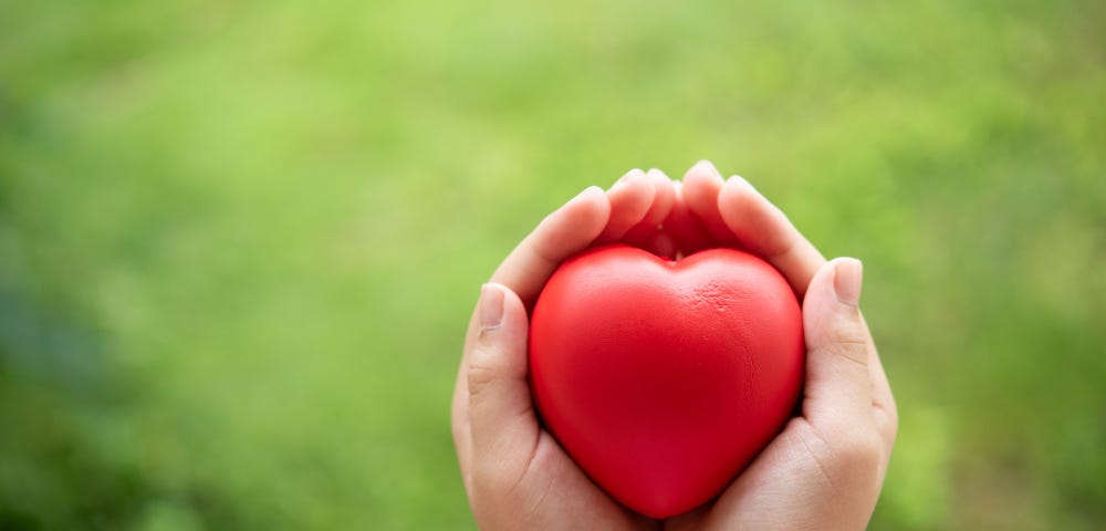 Child holding red rubber heart