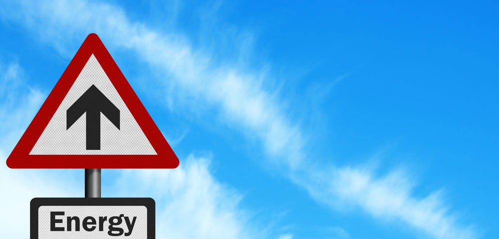 Picture of triangular street sign in front of blue sky, with an arrow pointing up and another sign below it with the words energy prices