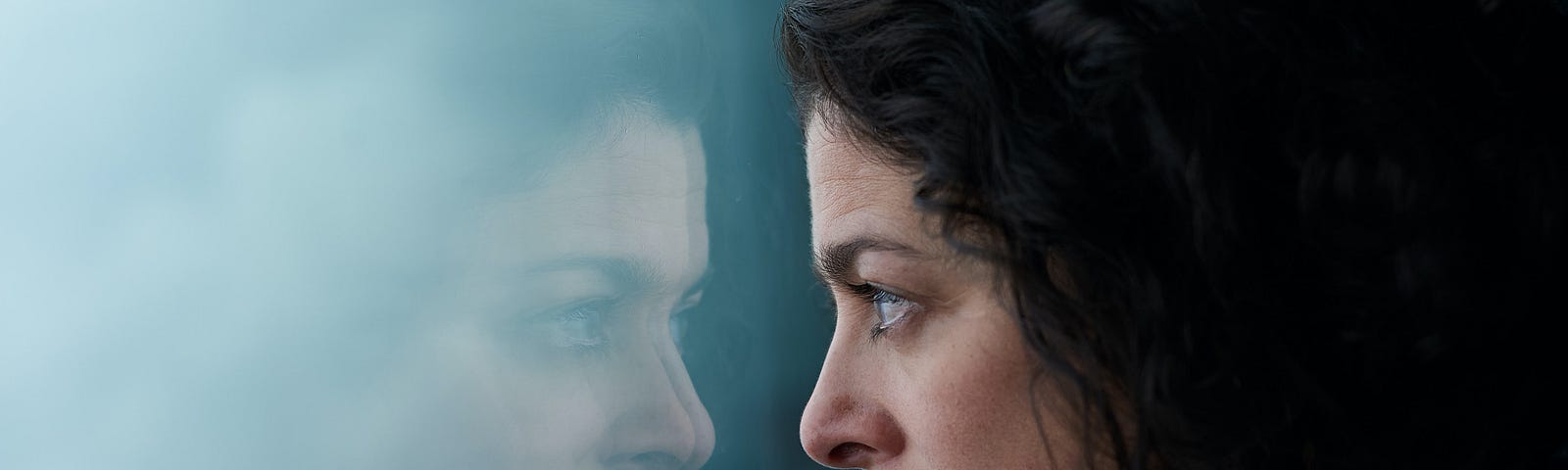 Person looking intensely through their reflection