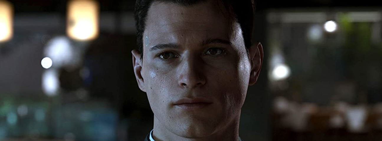 Still of Connor, one of the three main characters in Detroit Become Human. The image shows a close up of Connor’s face with a serious, almost thoughtful expression.