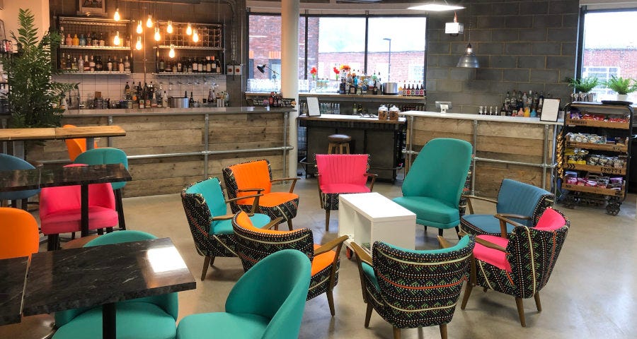 Brightly coloured comfortable chairs in a the food area of an upmarket co-working space