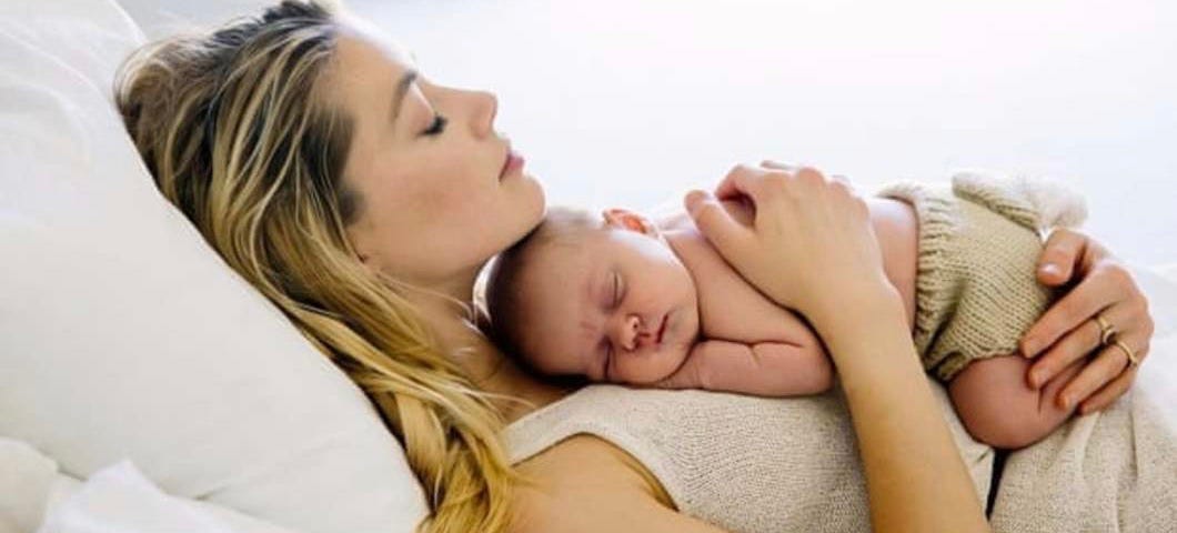 Amber heard lying down holding baby