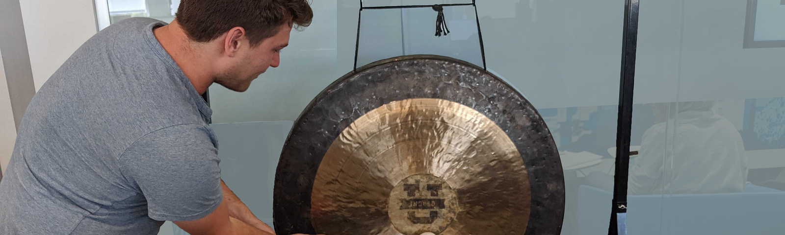 A new Indeedian bangs a gong to signal the completion of their first experiment