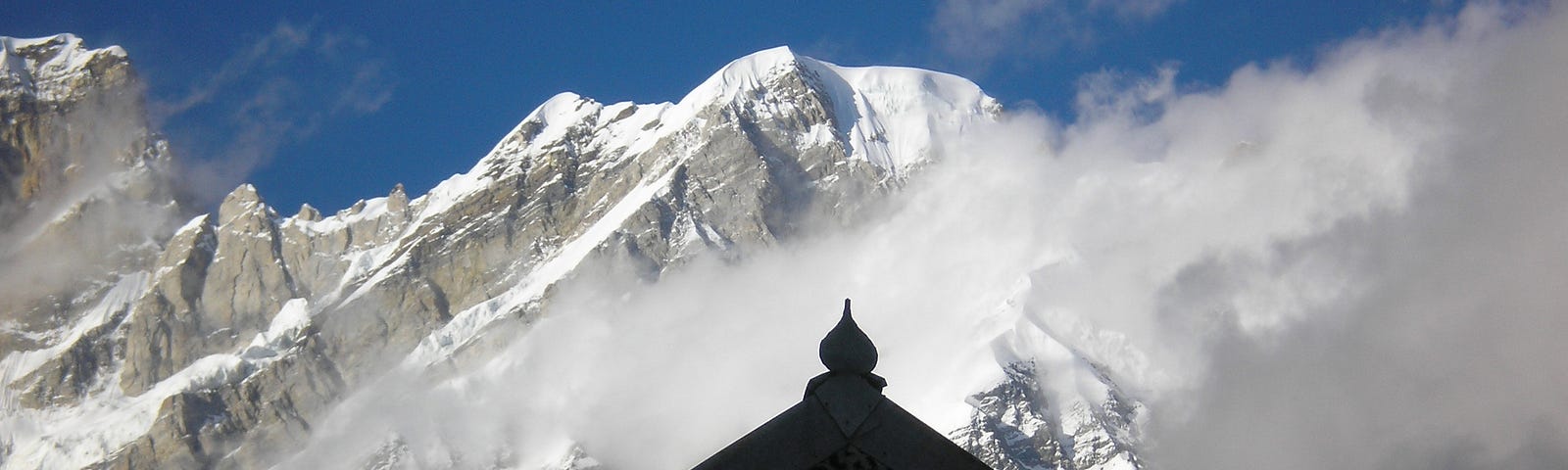 A temple in front of the snow-clad peaks.