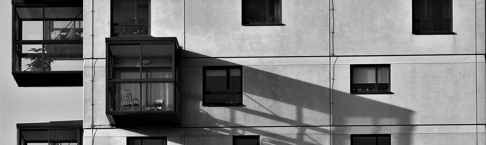 A grayscale photo of concrete building by hans middendorp from Pexels