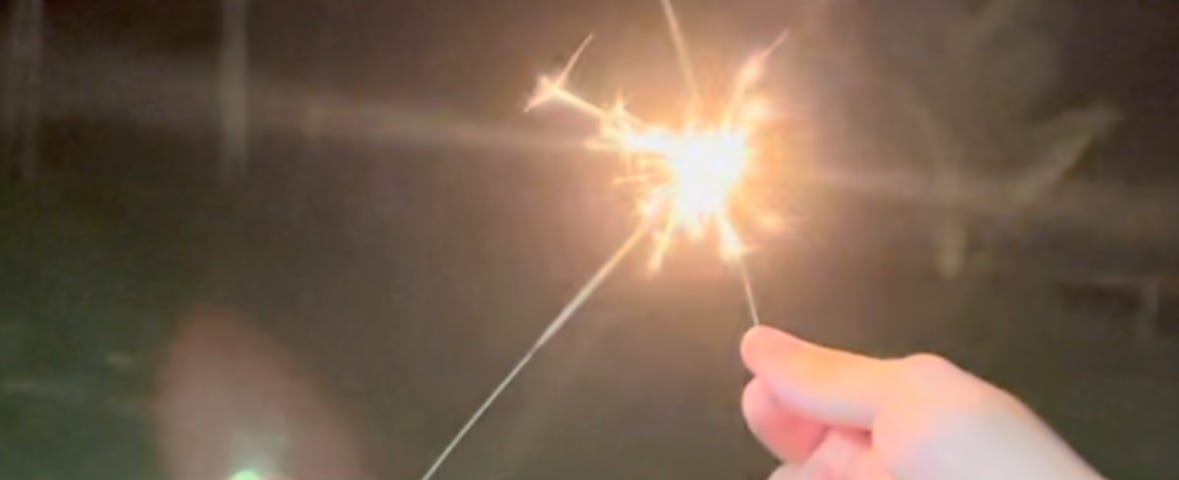 New Year’s celebration with fireworks in hands. A grandmother and her grandson share fireworks while celebrating. Hand pictures.