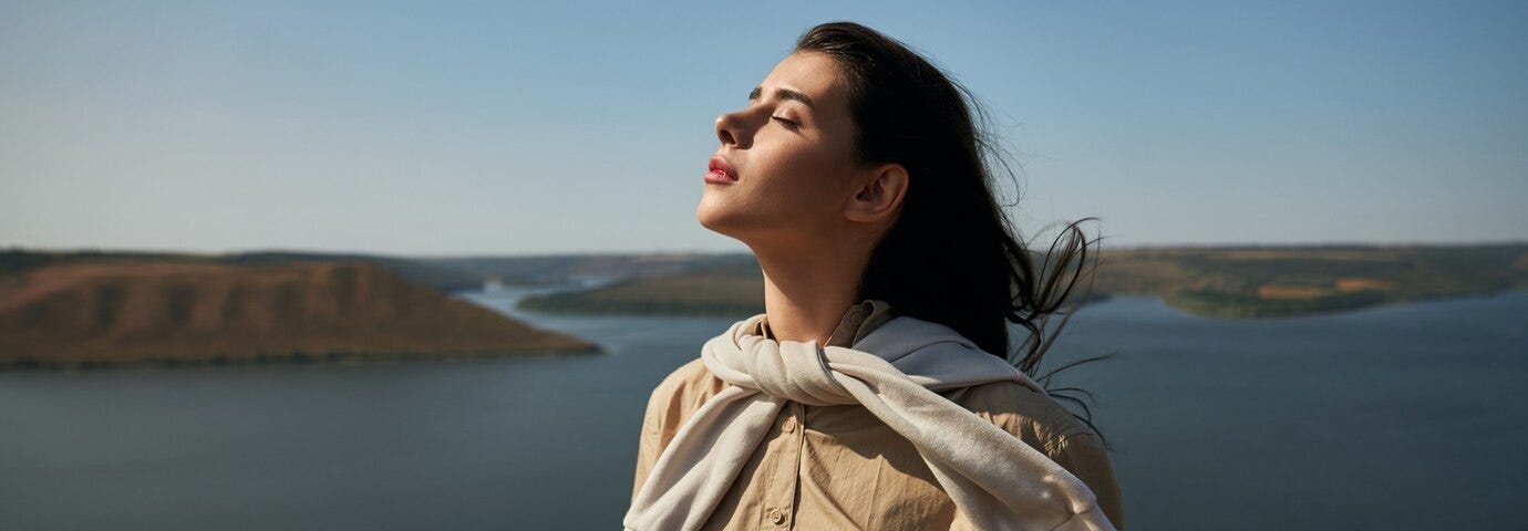 Photo of woman standing high with amazing view of Dniester River in background.