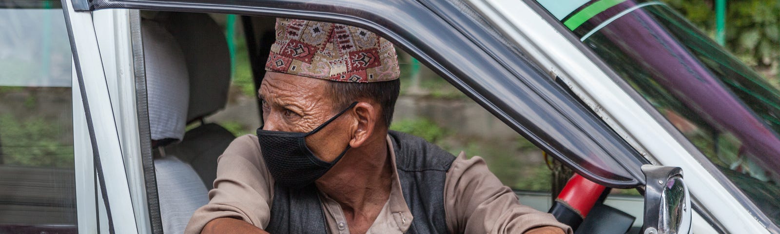 Taxi driver waiting for a fare wearing a face mask in Kathmandu, Nepal. Photo: © Mark Benham/Shutterstock