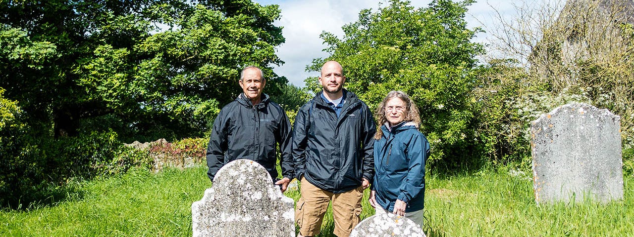Three people standing next to two gravestone — Searching for My Relatives: Kilkenny, Ireland