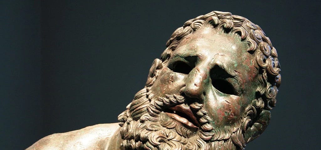 An ancient bronze statue of a boxer after a fight known as “The Boxer at Rest”.