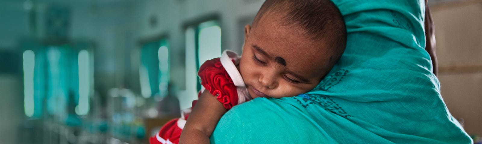 A mother brings her malnourished baby to the Child In Need Institute emergency ward in Kolkata, India, June 4, 2009. Photo by Andrew Aitchison/Alamy