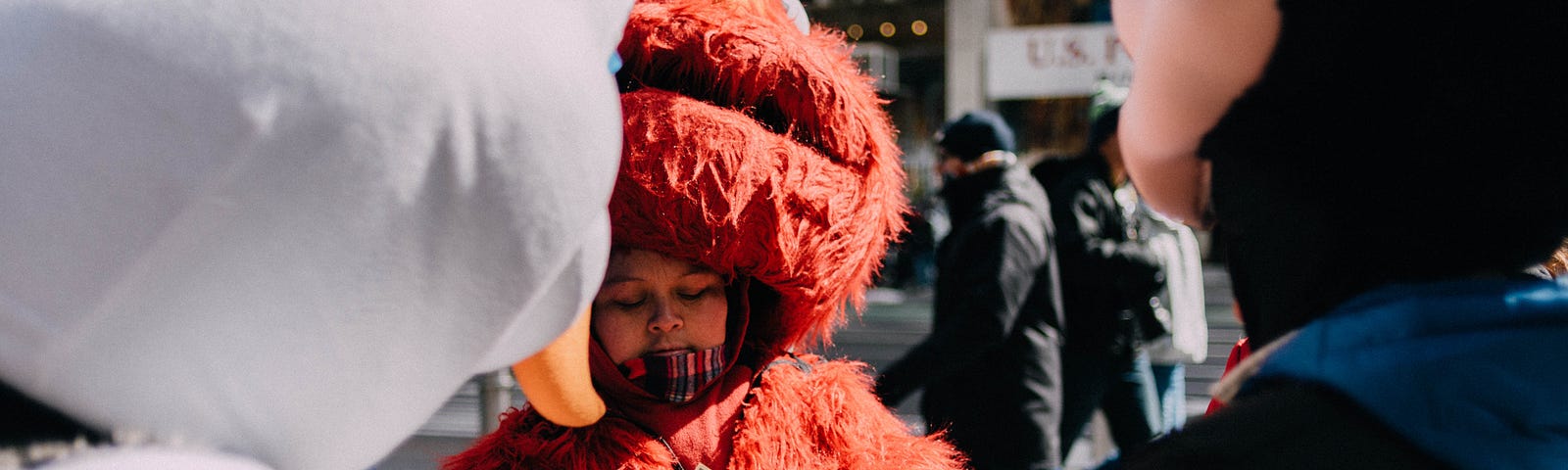 A person dressed in an Elmo suit, counting cash