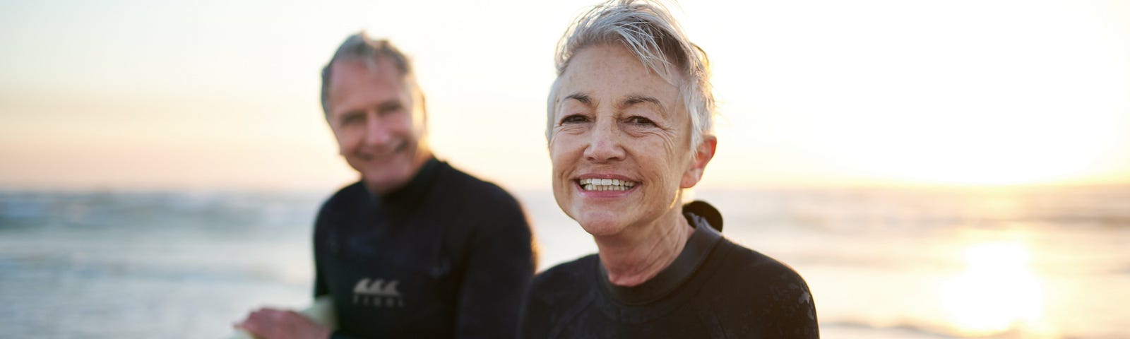 Photo  of a senior married couple coming in from surfing.