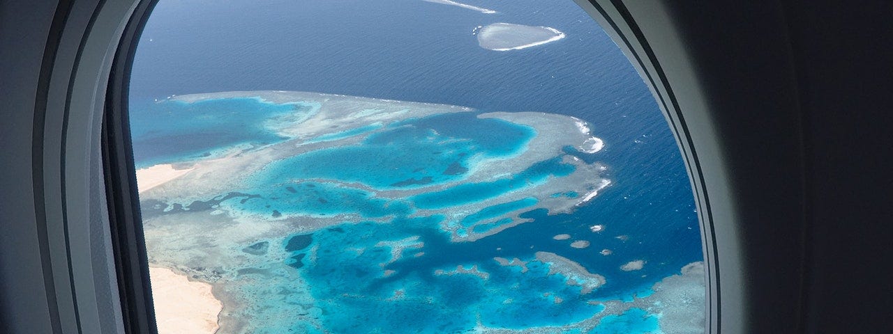 View of an island and blue water from an airplane window