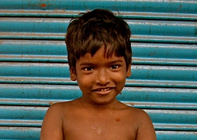 Young boy in Madras (India) with beautiful and tender smile hold two chicks in his hand. Life is alway life.