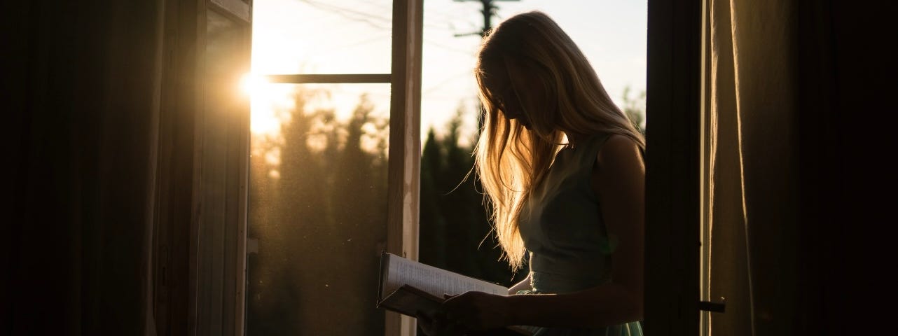 Woman reading by the sunlight. Photo by Yuri Efremov on Unsplash