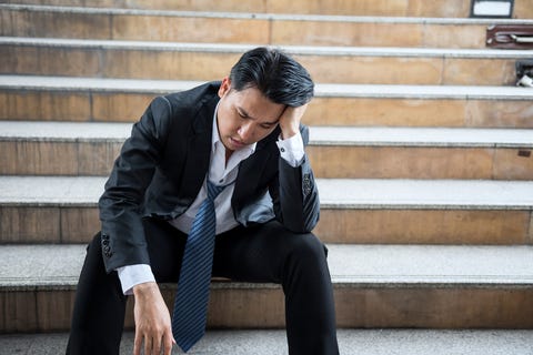 Desperate sad middle-age businessman suffer emotional pain grief and deep depression sit on urban street stair.