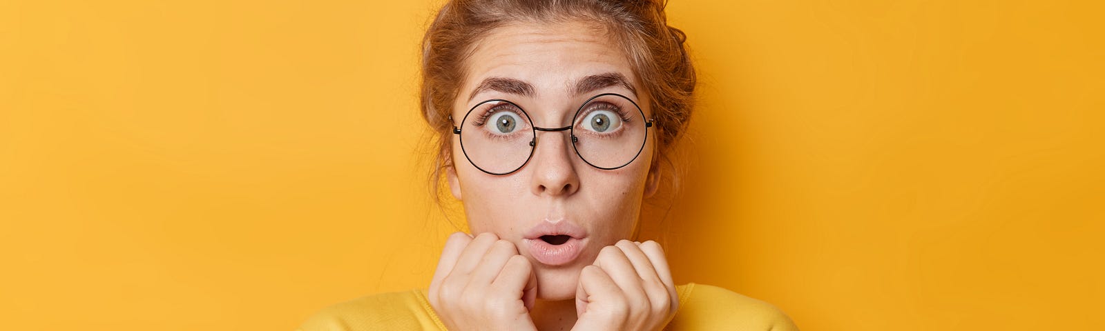 surprised woman in yellow sweater and yellow background