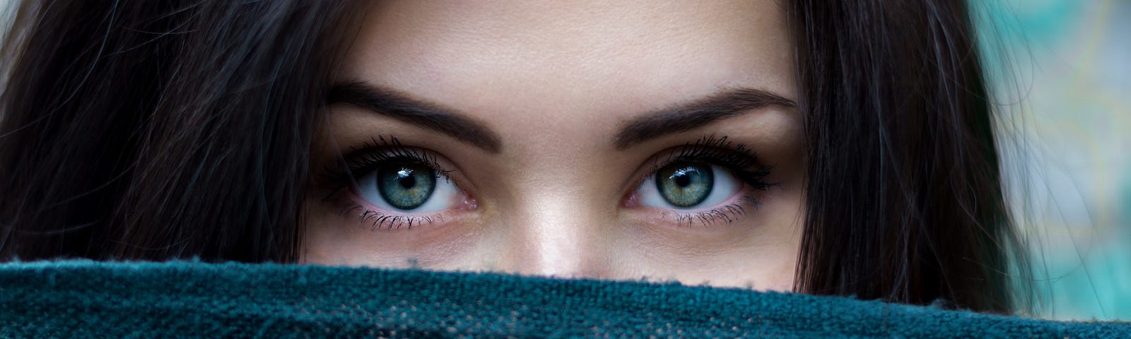 woman looking over a scarf in front of her face