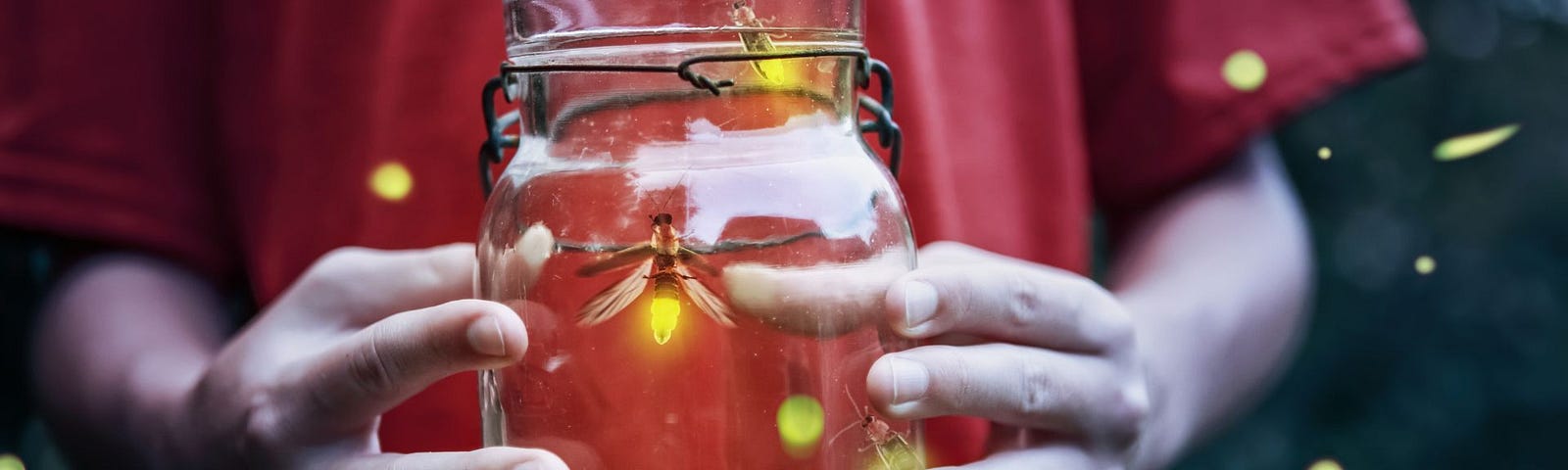 Photo of person holding a jar with fireflies captured inside.