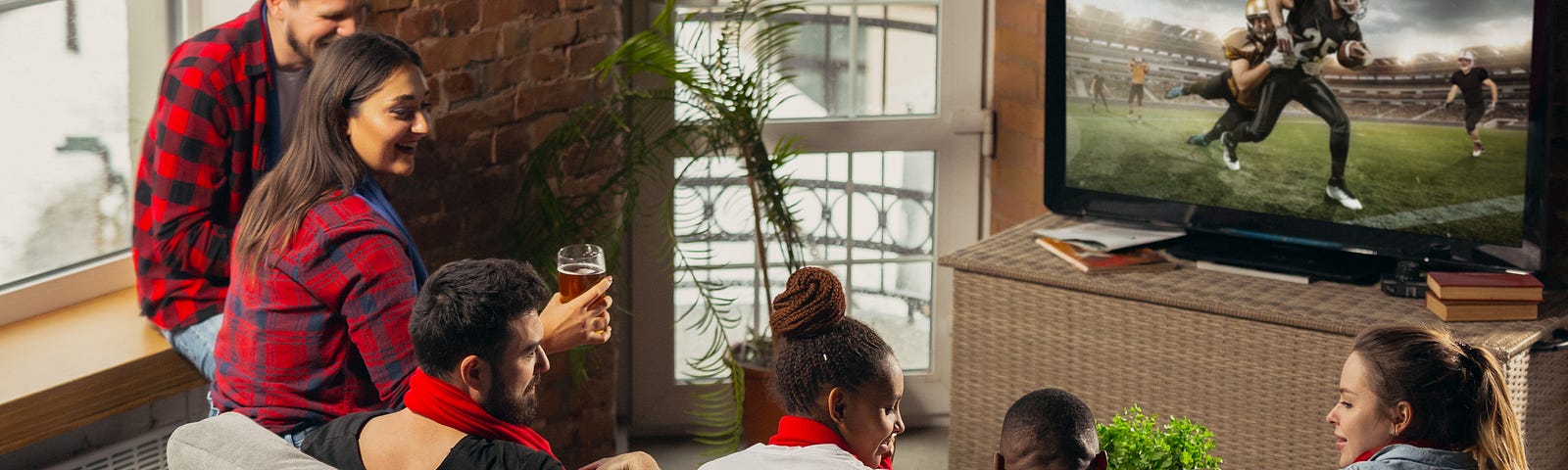 The photo shows friends sitting on a couch watching football.