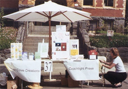 Shared outdoor booth with an umbrella at a book festival
