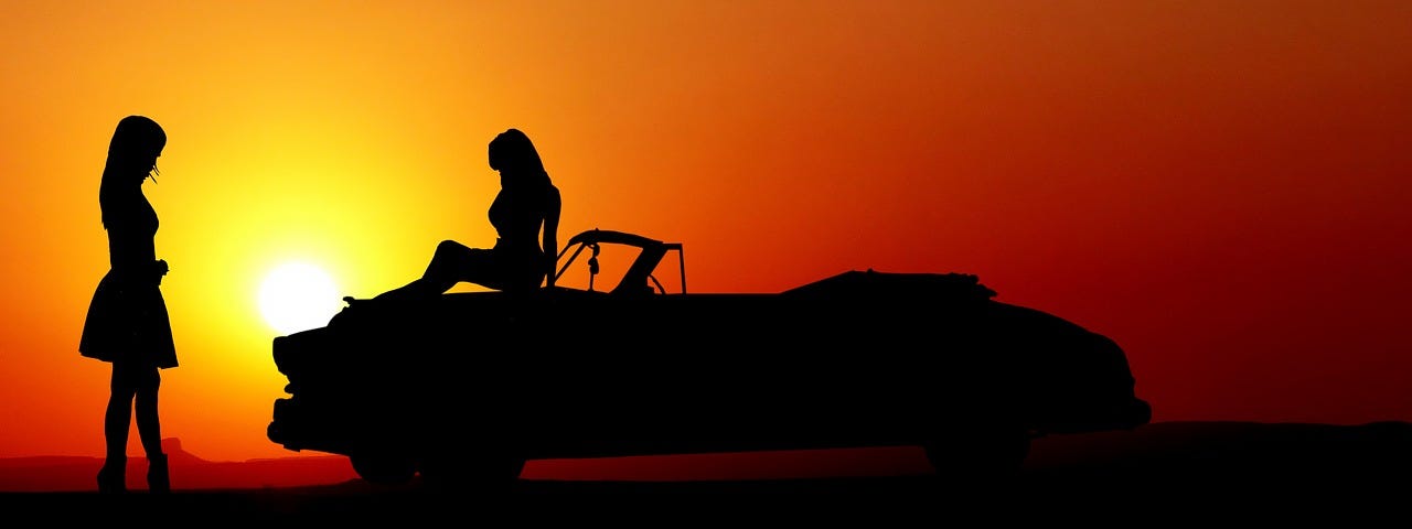 Two female besties cruising the summer miles in their souped up car with the music blaring.