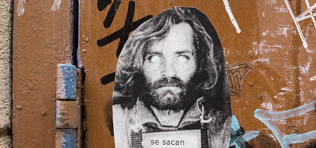 picture of Charles Manson on a wall with graffiti