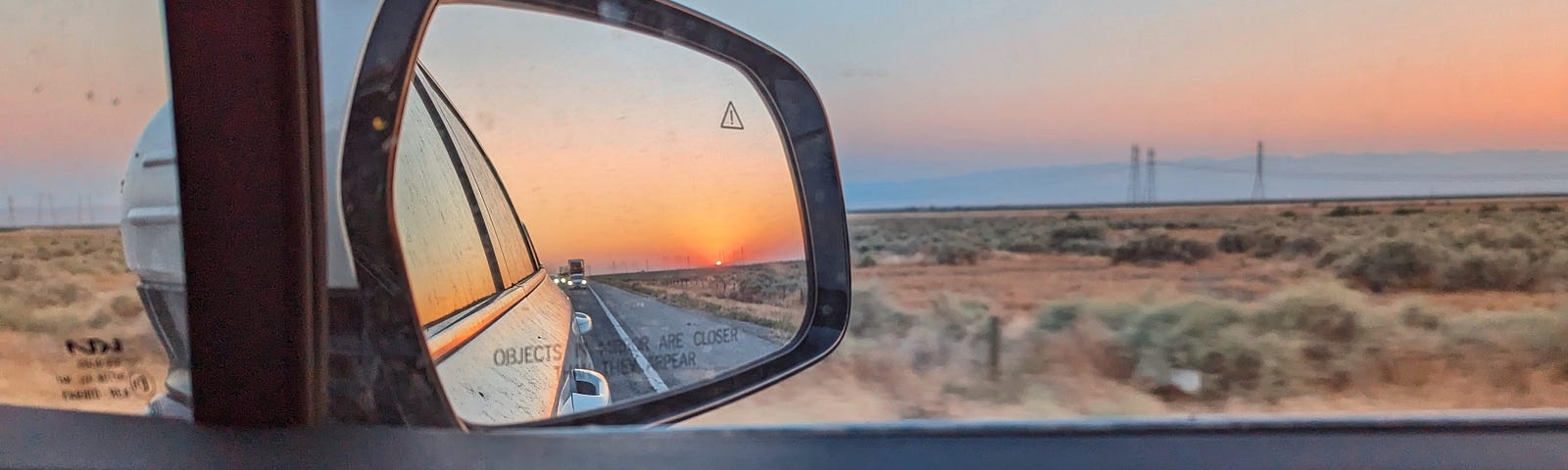 Sunset reflected in a side-view mirror