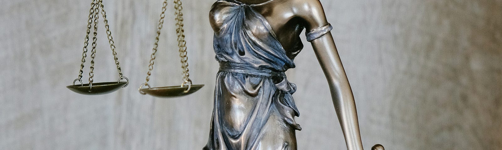 Bronze statue of Lady Justice with a set of scales.