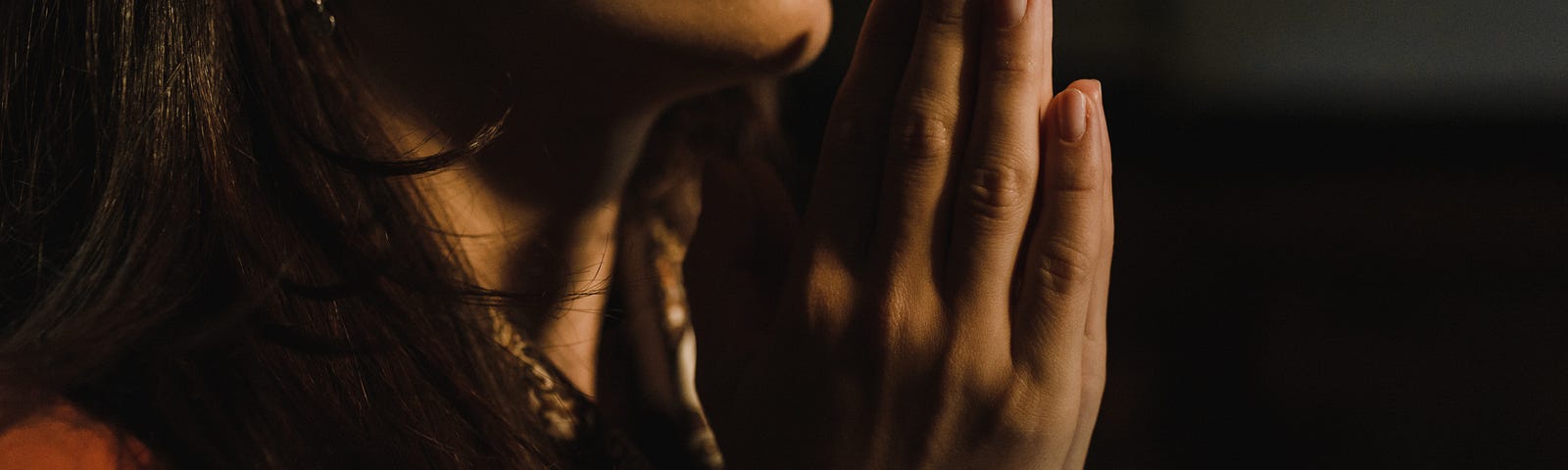 Woman praying with folded hands.