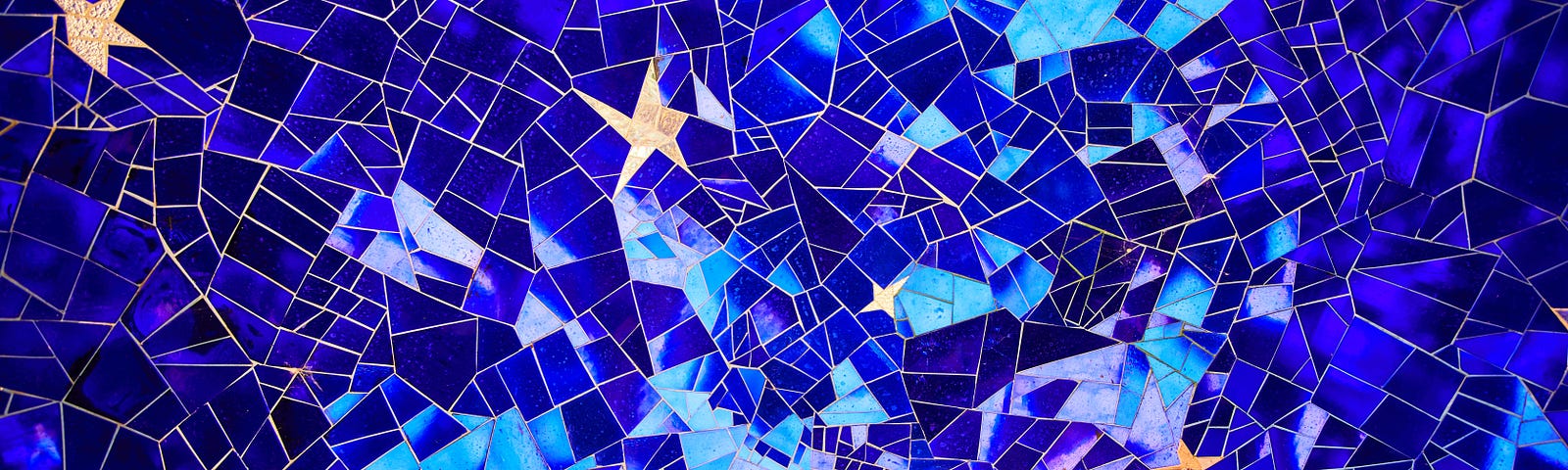 Splintered tile mosaic in shades of blue with stars and crescent moon.