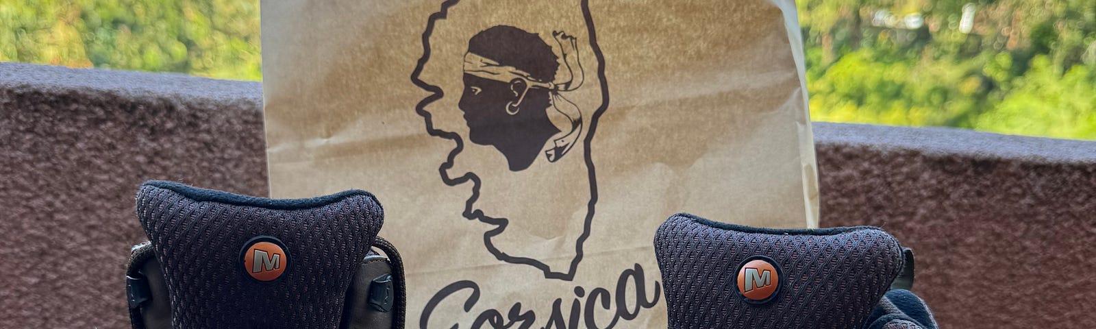 Hiking boots against shopping bag with Corsica logo