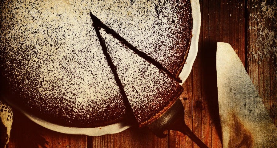 Photo of a chocolate cake from above with a piece cut out.