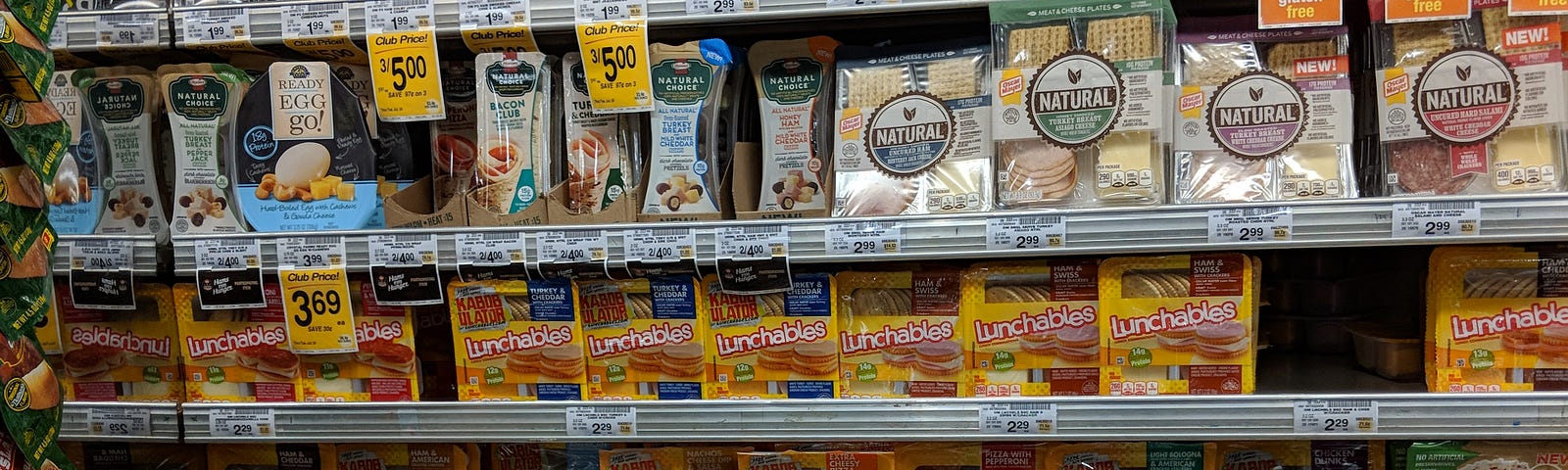 A display at a grocery store of various lunch kits, including Lunchables.