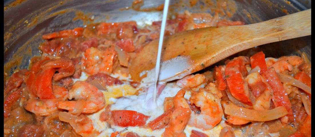 Adding cream to a pot while making Busy Day Pasta with Creamy Shrimp Sauce