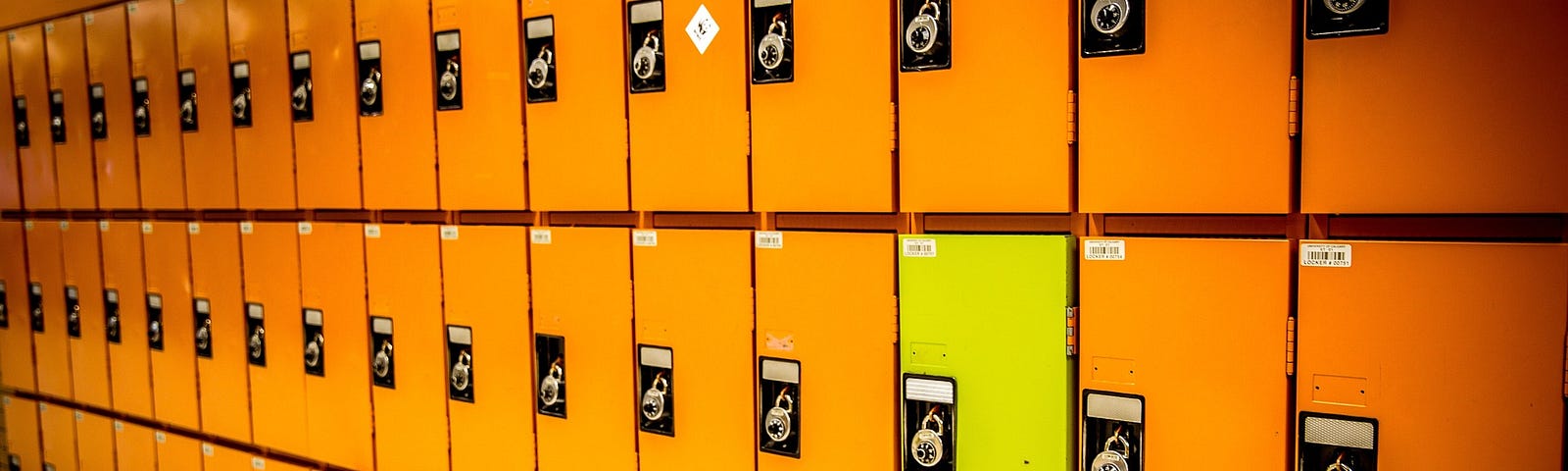 Identical orange lockers with one yellow locker.