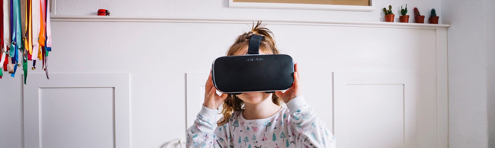 Little girl in pajamas and VR goggles