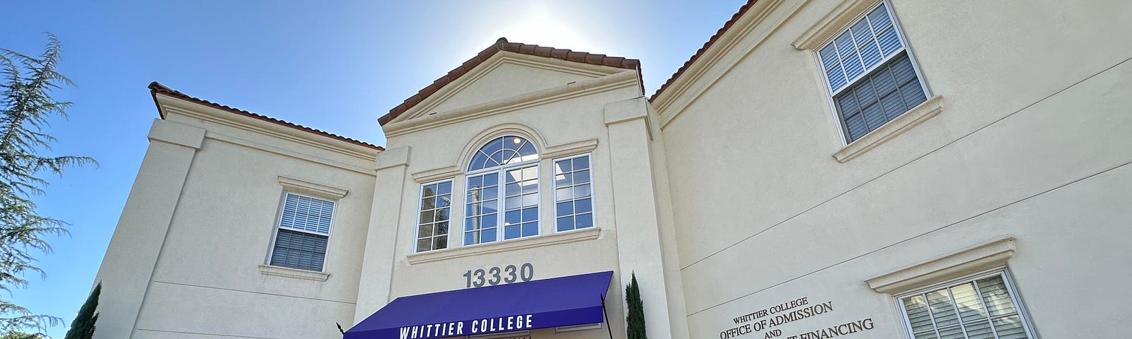 A 0.5 image of the Whittier College Office of Admissions and Financial Aid building against a backdrop of a blue sky.