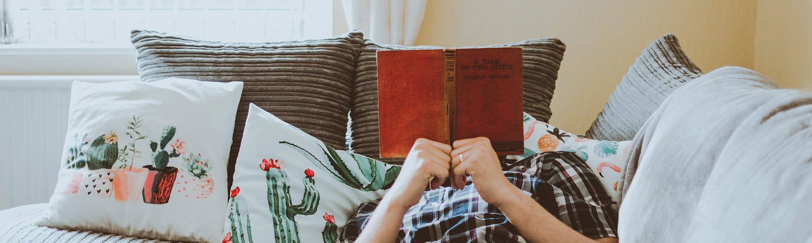 man on a sofa, reading a book